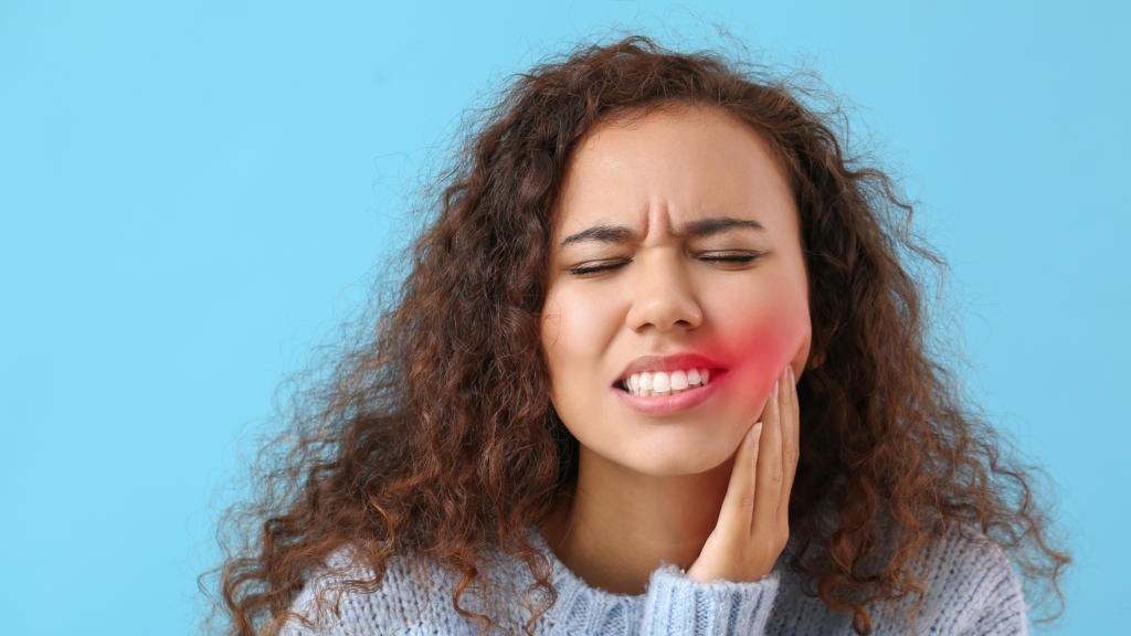 Image of a young woman experiencing a toothache during a dental emergency